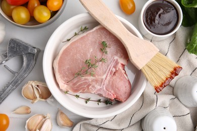 Flat lay composition with raw meat, thyme and marinade on white table