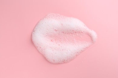 Sample of fluffy foam on pink background, top view