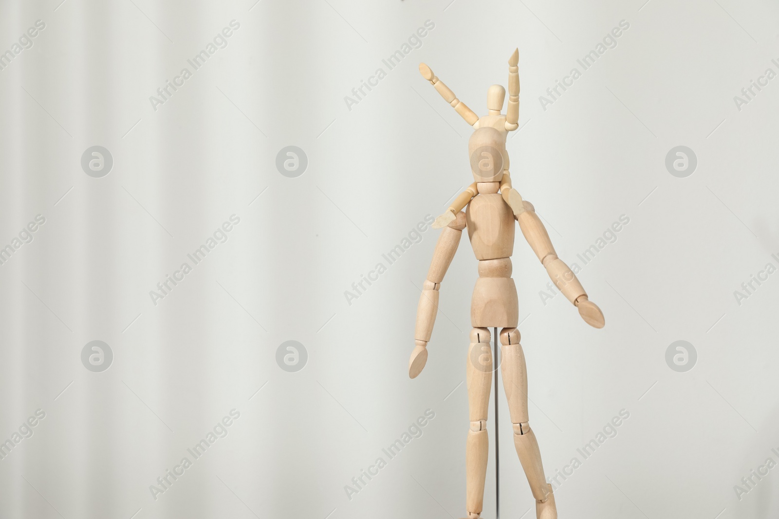 Photo of Wooden mannequins of parent with child on light background, space for text. Family Day