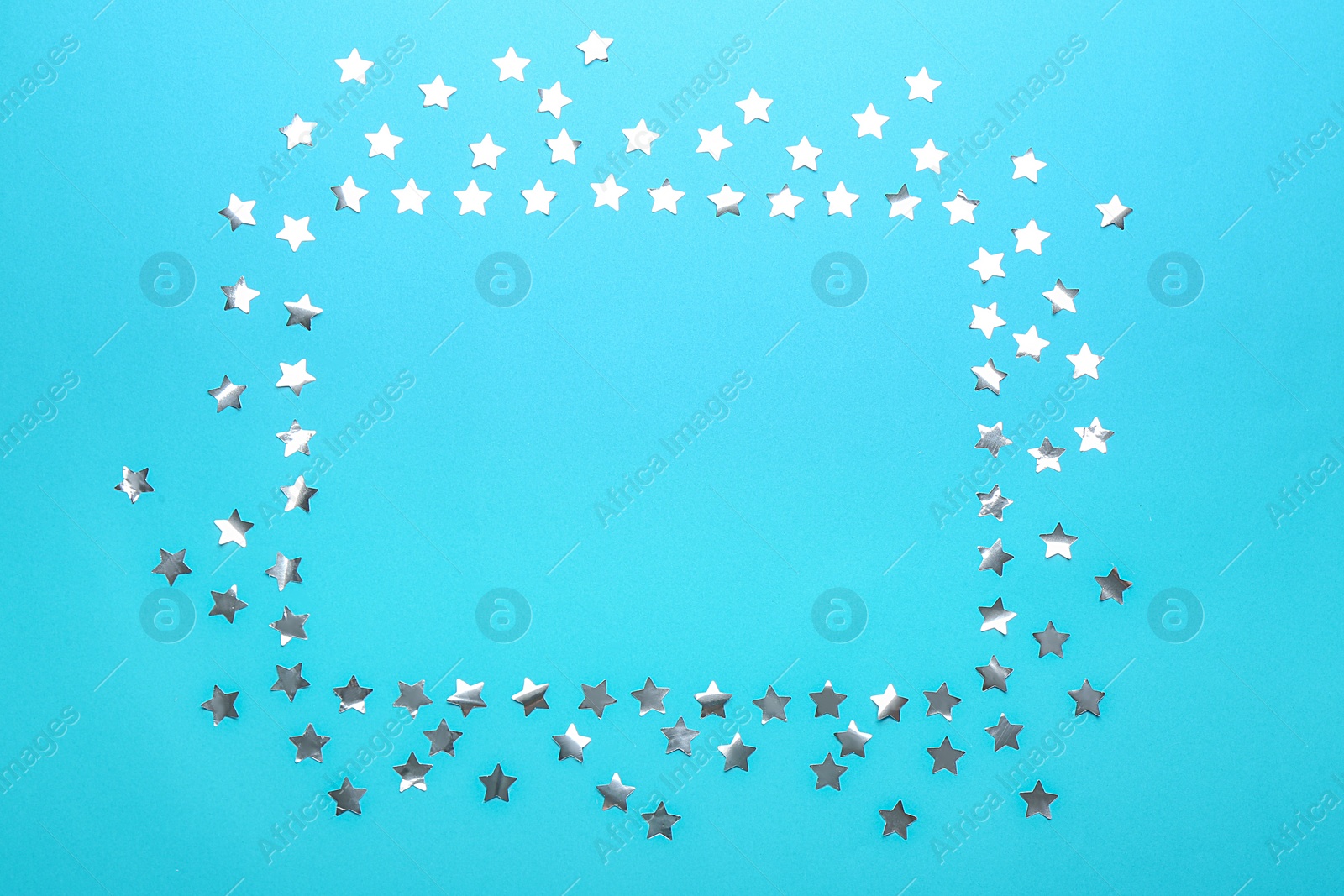 Photo of Frame made of confetti stars with space for text on blue background, top view. Christmas celebration