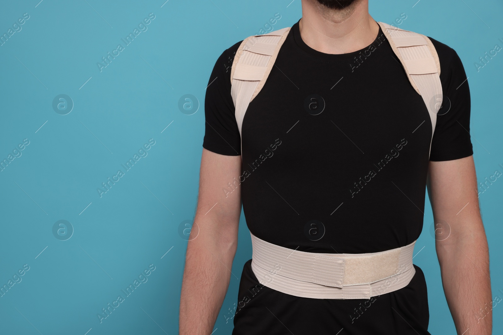 Photo of Closeup view of man with orthopedic corset on blue background. Space for text