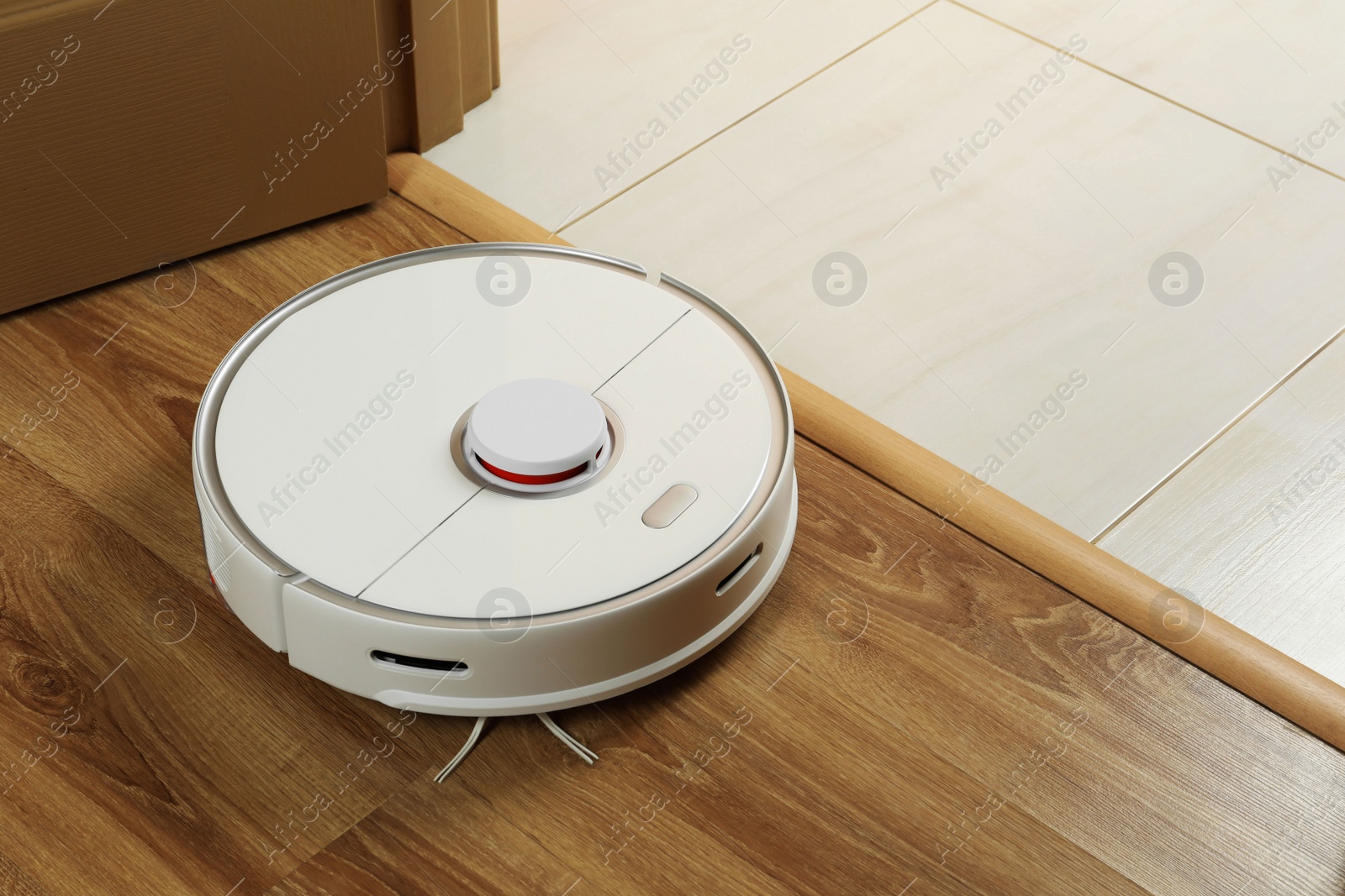 Photo of Modern robotic vacuum cleaner on wooden floor indoors