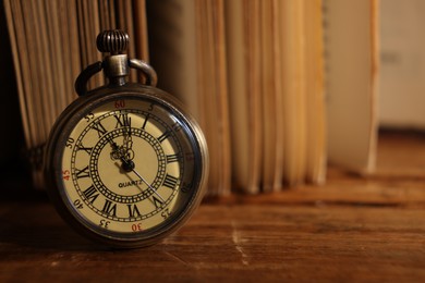 Pocket clock on wooden table, closeup. Space for text