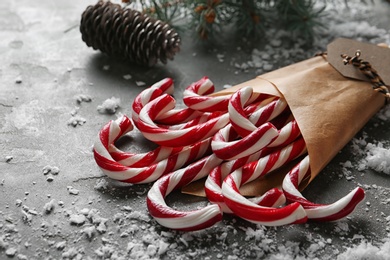 Photo of Candy canes on grey table. Traditional Christmas treat