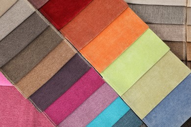 Photo of Fabric samples of different colors as background, top view