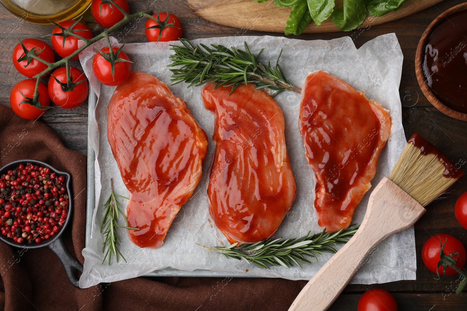 Photo of Flat lay composition with raw marinated meat, products and basting brush on wooden table