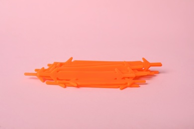 Photo of Orange silicone shoe laces on light pink background