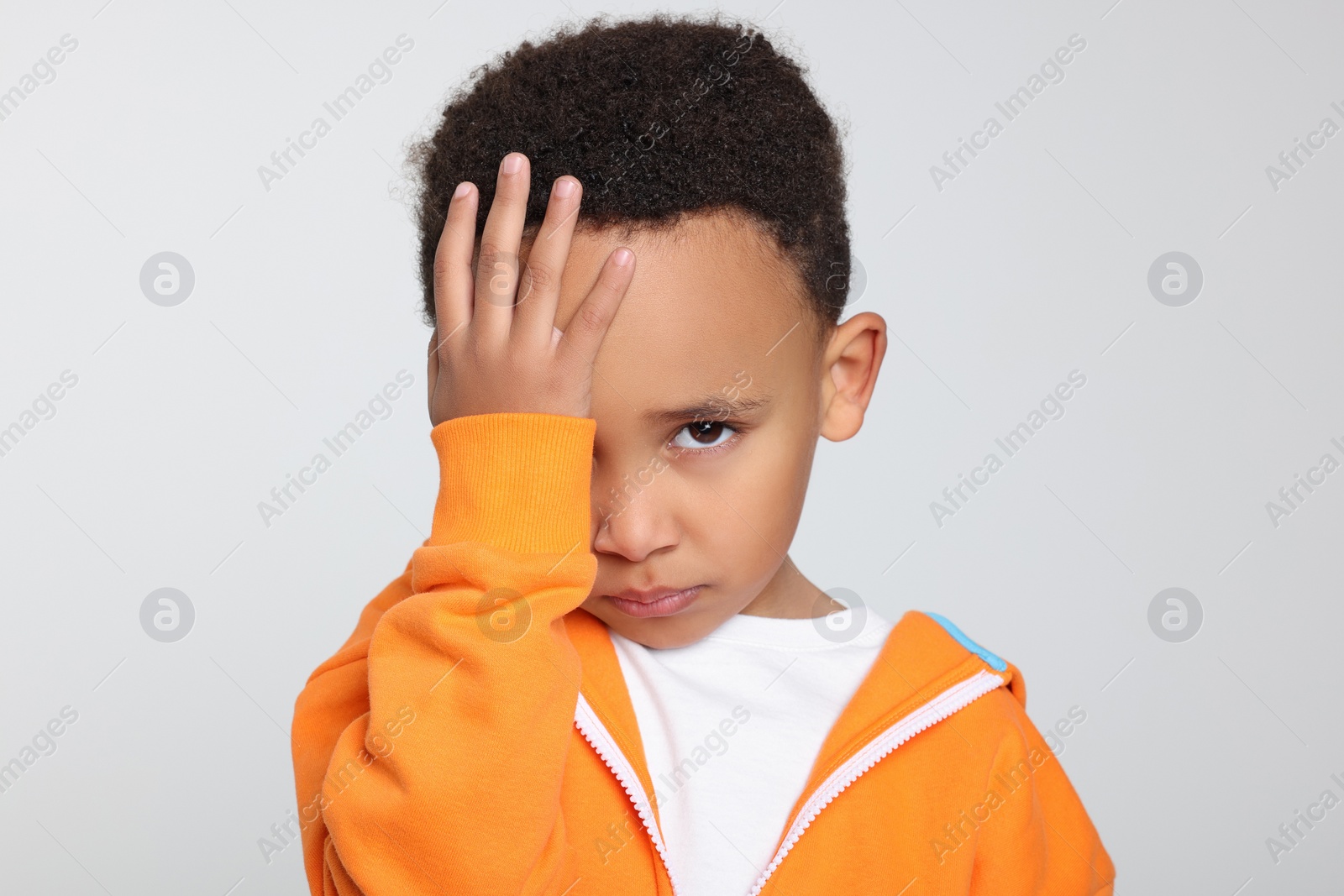 Photo of Emotional African-American boy on light grey background