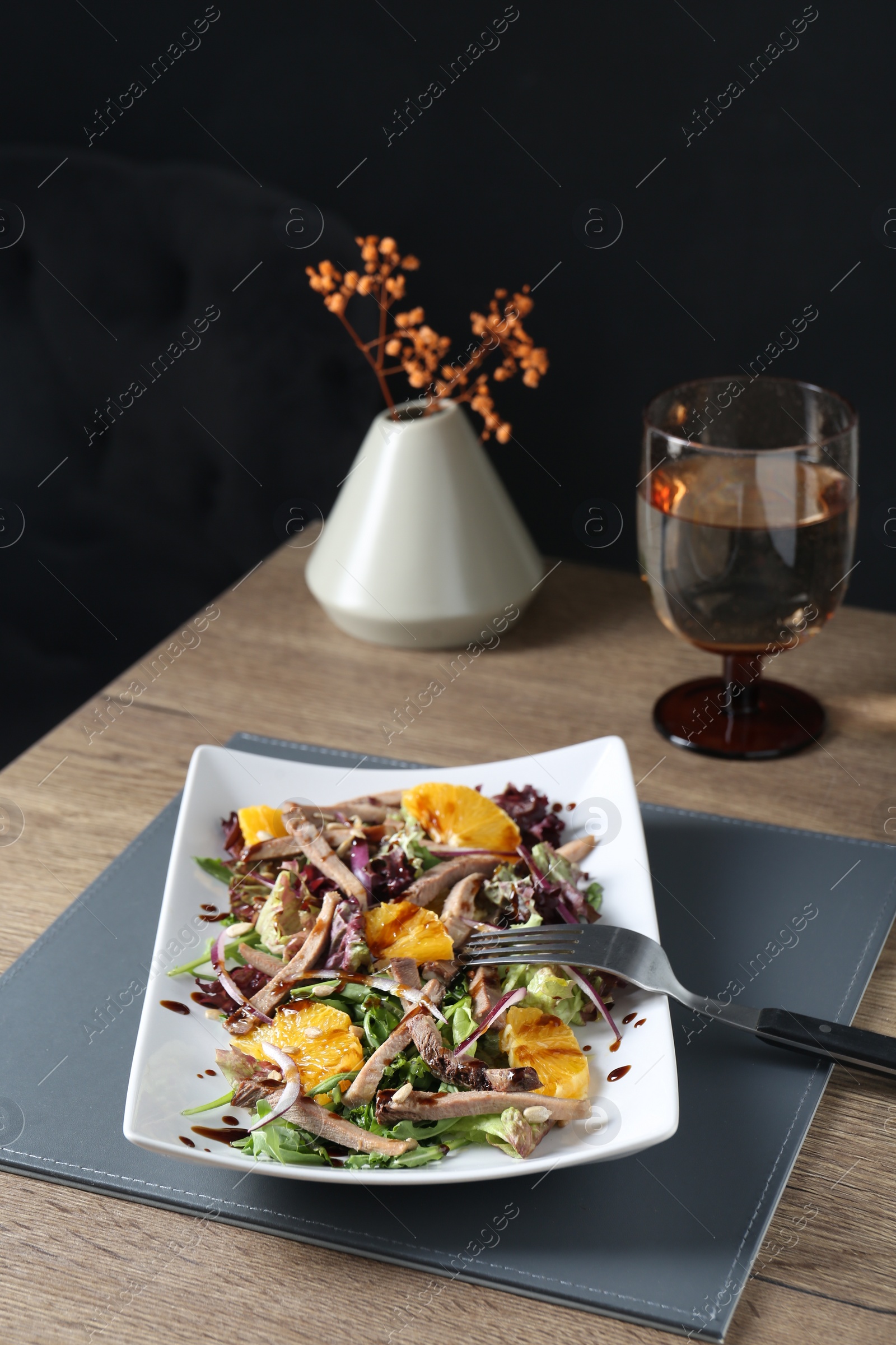 Photo of Delicious salad with beef tongue, orange, onion and fork served on wooden table