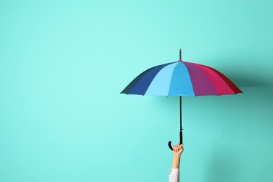 Photo of Woman holding beautiful umbrella on color background with space for design