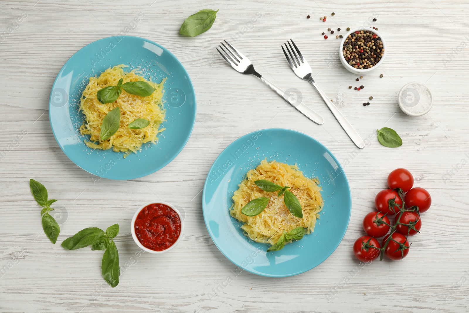 Photo of Tasty spaghetti squash with basil served on white wooden table, flat lay