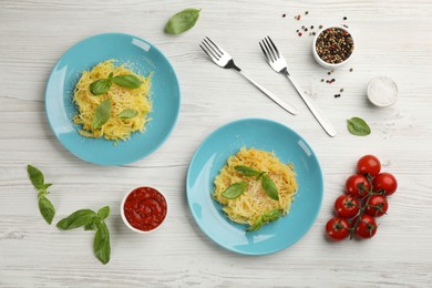 Photo of Tasty spaghetti squash with basil served on white wooden table, flat lay