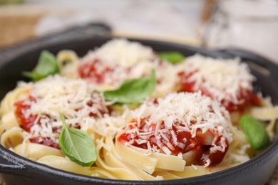 Photo of Delicious pasta with tomato sauce, basil and parmesan cheese in bowl, closeup