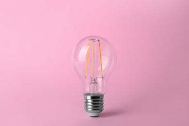 Photo of Vintage filament lamp bulb on pink background