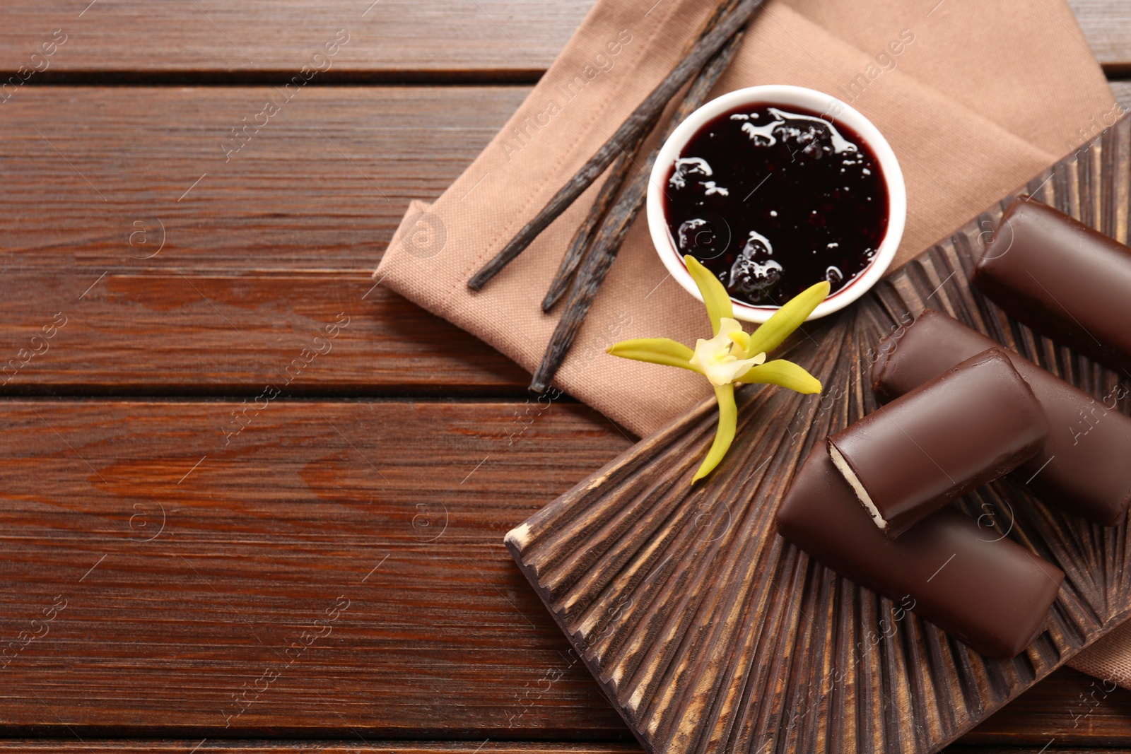 Photo of Glazed vanilla curd cheese bars served on wooden table, flat lay. Space for text