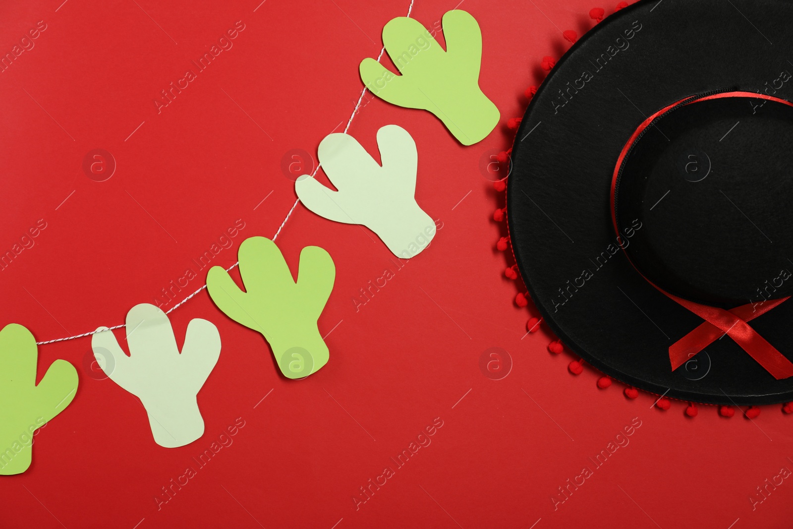 Photo of Black Flamenco hat and garland on red background