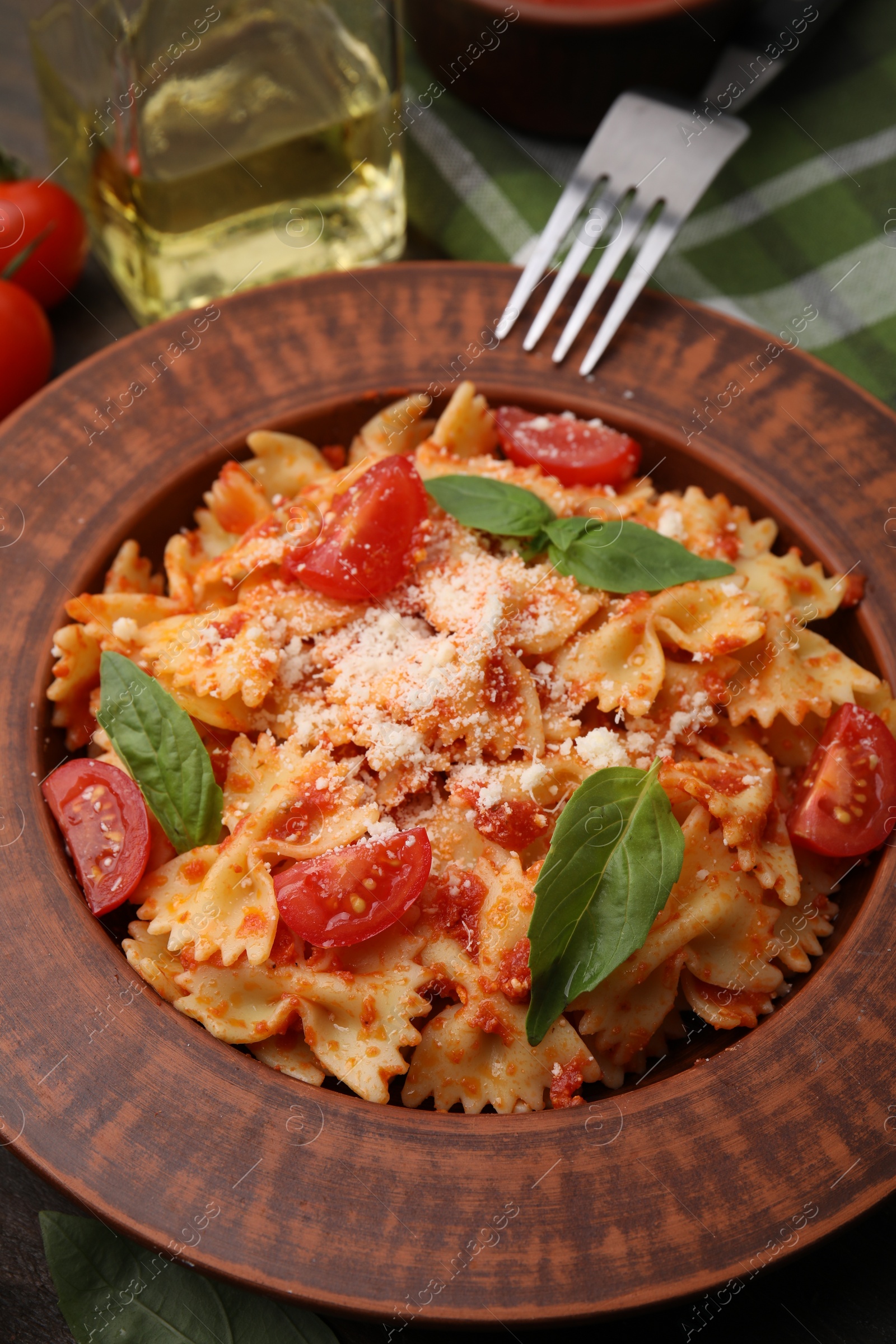 Photo of Tasty pasta with tomato, cheese and fork on table, closeup