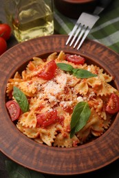 Tasty pasta with tomato, cheese and fork on table, closeup