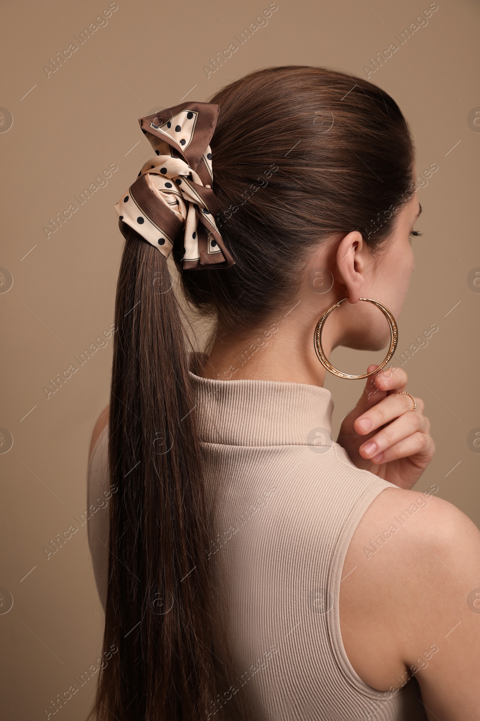 Photo of Young woman with stylish bandana on beige background