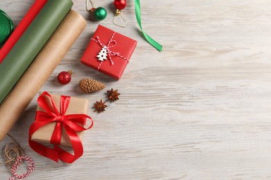 Flat lay composition with beautiful gift boxes and Christmas decorations on white wooden table. Space for text