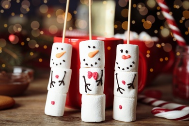 Funny snowmen made of marshmallows on wooden table