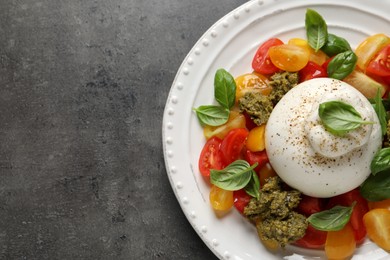 Photo of Delicious burrata salad on grey table, top view. Space for text