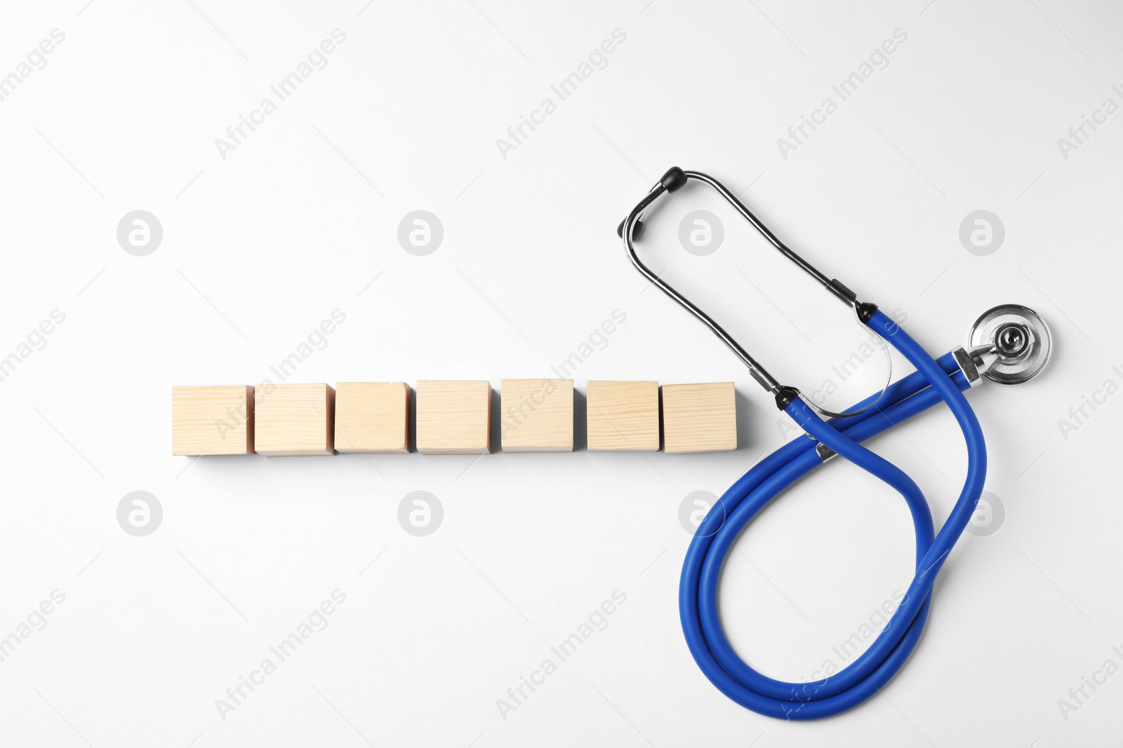 Photo of Wooden cubes with space for text and stethoscope on white background. Urology concept