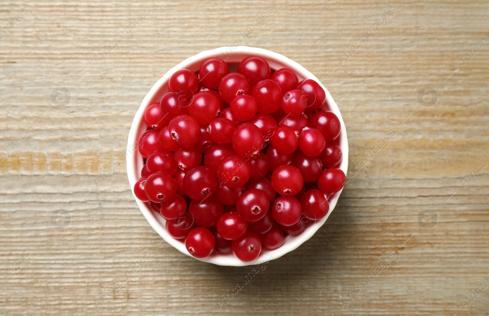 Photo of Tasty ripe cranberries on wooden table, top view