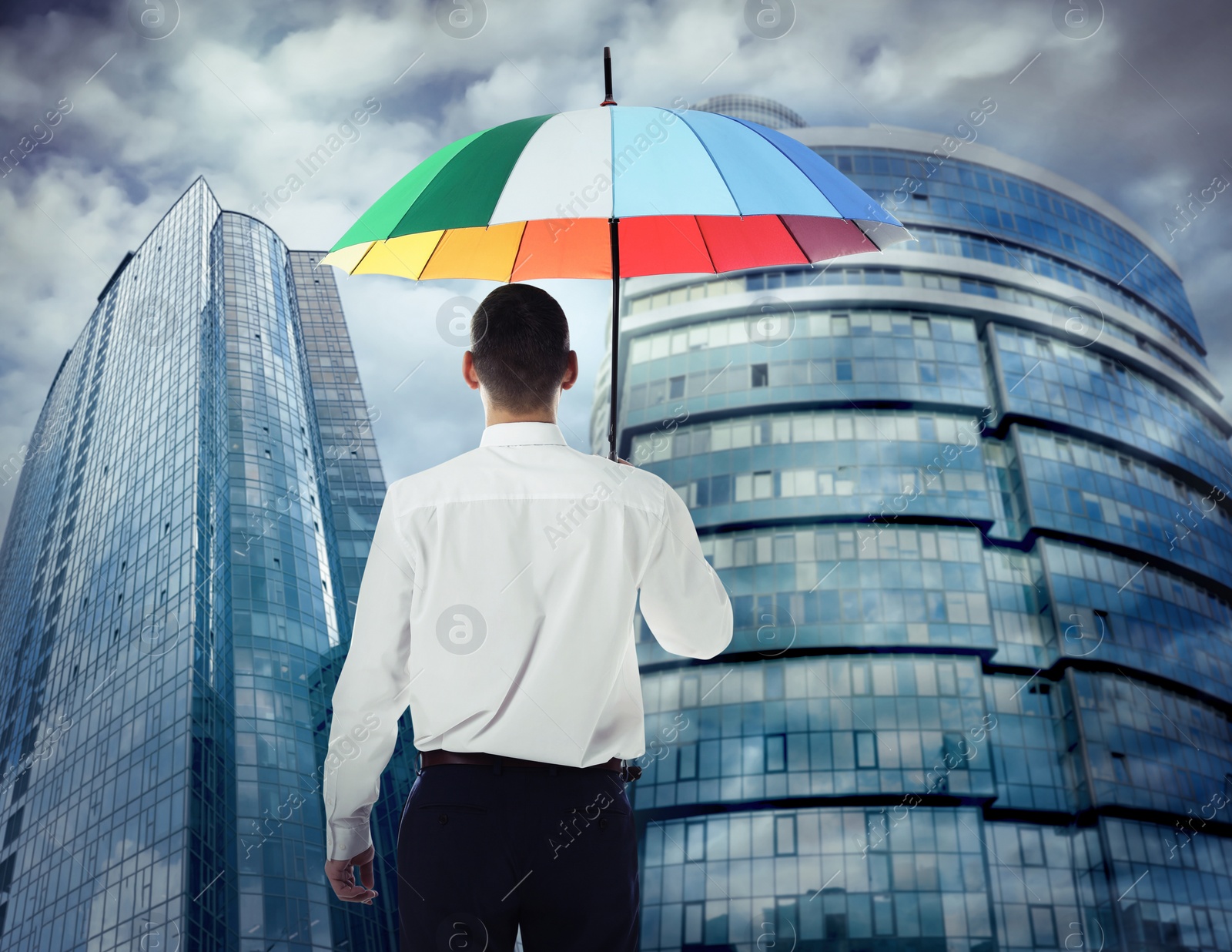 Image of Businessman with umbrella in city center. Insurance concept