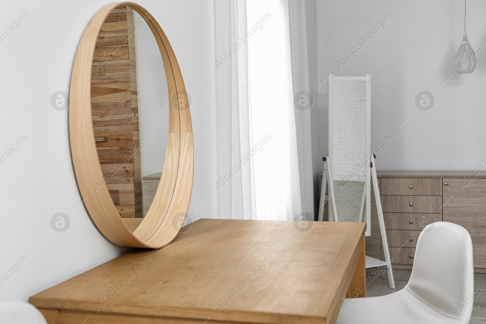 Photo of Makeup room interior with wooden table and mirror near white wall