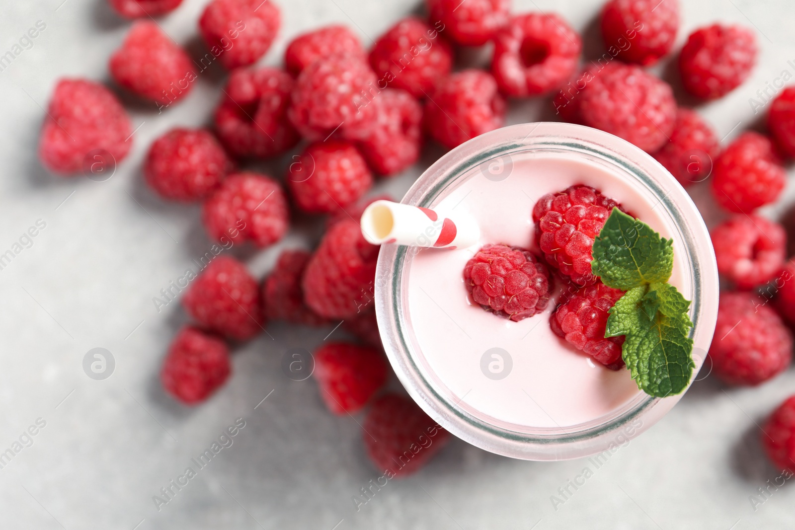 Image of Yummy raspberry smoothie in jar and fresh berries on table, flat lay 