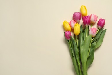 Photo of Beautiful colorful tulip flowers on beige background, flat lay. Space for text