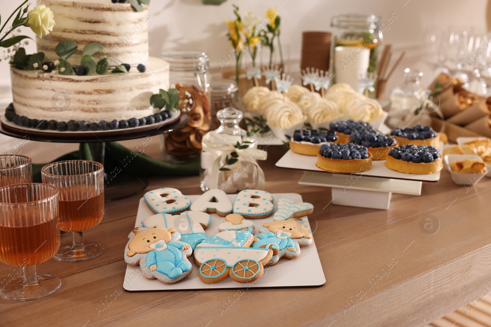 Photo of Beautiful cake and other treats on table in room. Baby shower party