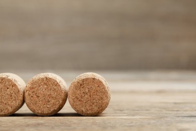 Corks of wine bottles on wooden table, closeup. Space for text