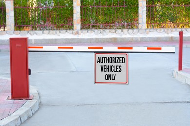 Image of Sign with text Authorized Vehicles Only on boom barrier outdoors
