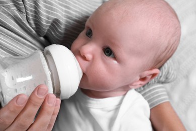 Photo of Mother feeding her little baby from bottle, closeup