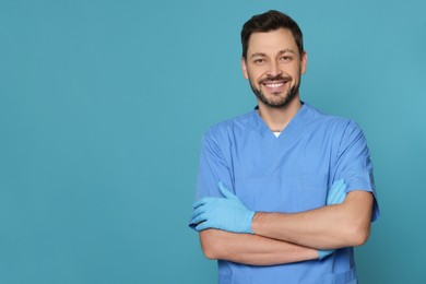 Photo of Doctor or medical assistant (male nurse) in uniform on turquoise background. Space for text
