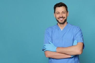 Doctor or medical assistant (male nurse) in uniform on turquoise background. Space for text