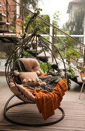 Indoor terrace interior with hanging chair and green plants