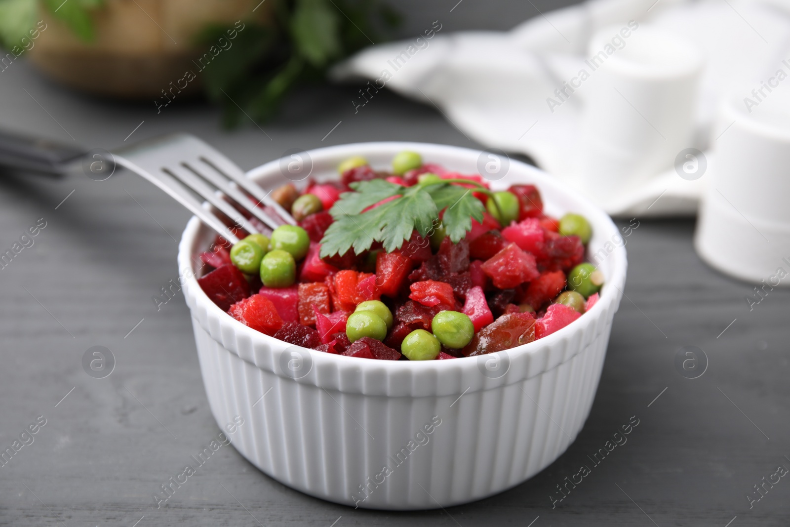 Photo of Delicious vinaigrette salad on grey wooden table, closeup