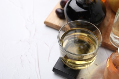 Photo of Different types of vinegar on white table, space for text