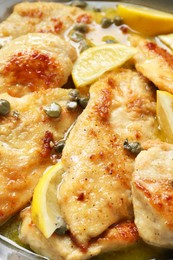 Photo of Delicious chicken piccata with lemons in pot, closeup