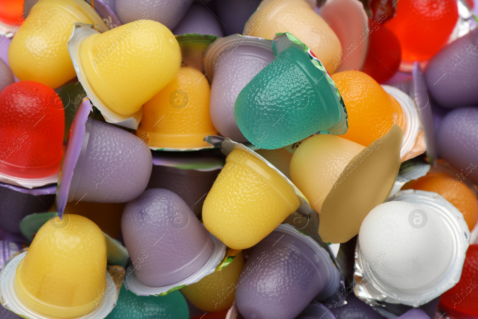 Photo of Tasty bright jelly cups as background, top view