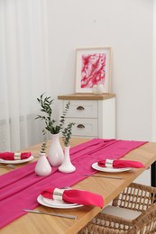 Photo of Beautiful table setting and vases with green branches in dining room