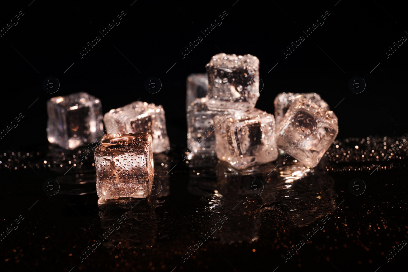 Photo of Pile of crystal clear ice cubes on black background