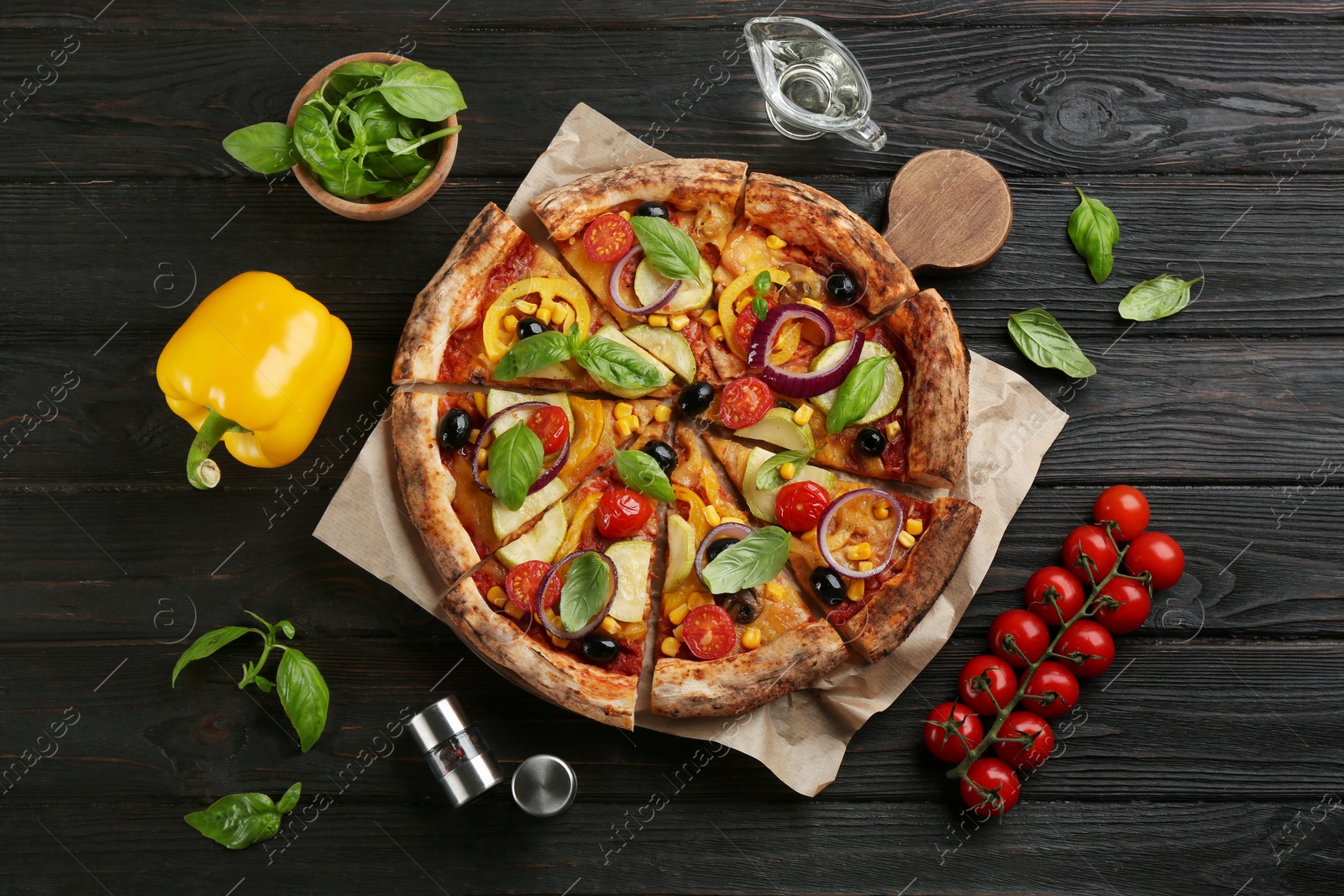 Photo of Flat lay composition with vegetable pizza on black wooden table