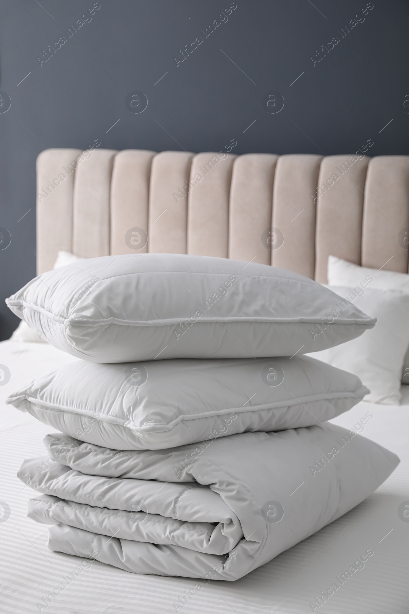 Photo of Soft folded blanket and pillows on bed indoors