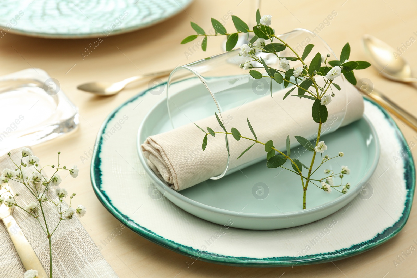 Photo of Elegant table setting with flowers and leaves, closeup