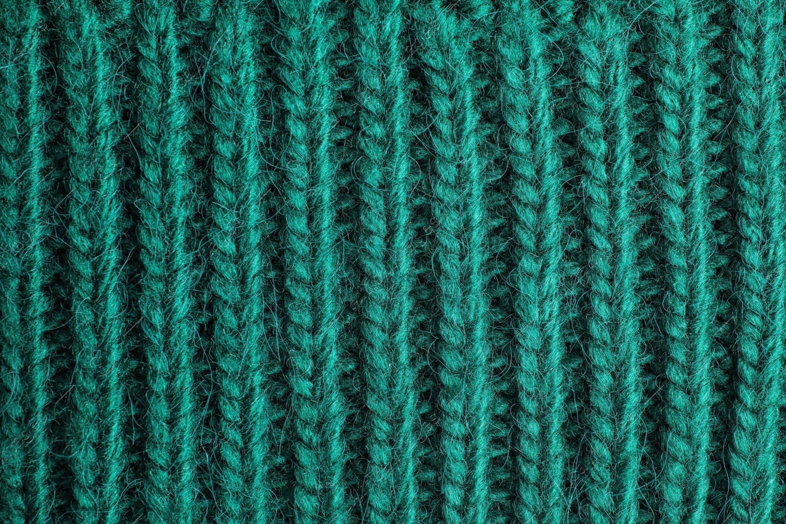 Photo of Green knitted sweater as background, closeup view