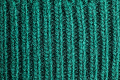 Green knitted sweater as background, closeup view